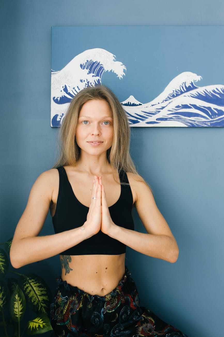 Woman in a calm yoga pose against a light blue background.